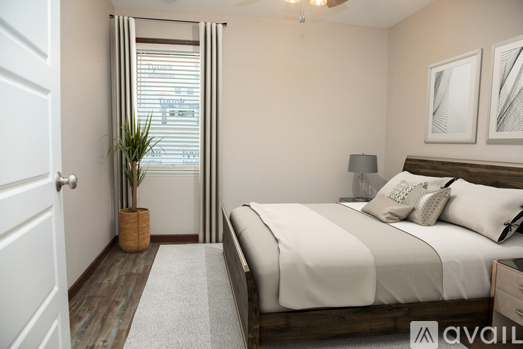 A bedroom with a large bed and a plant in a wicker pot.
