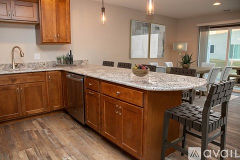 A kitchen with wooden cabinets and a granite countertop.