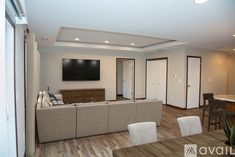 A living room with a couch, a television, and a dining table.