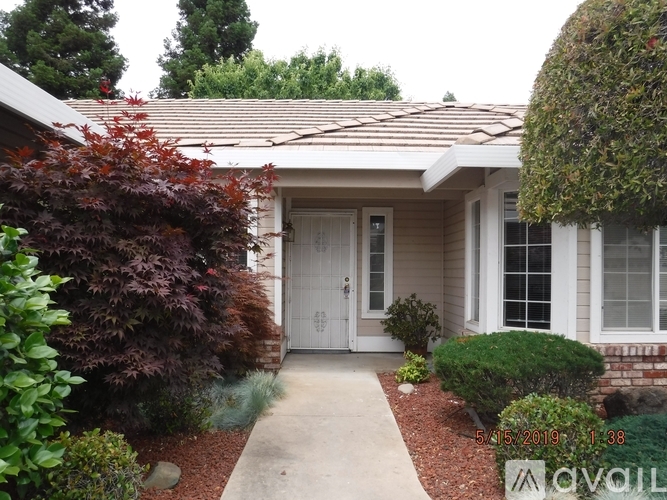 A house with a white door and a small garden in front.