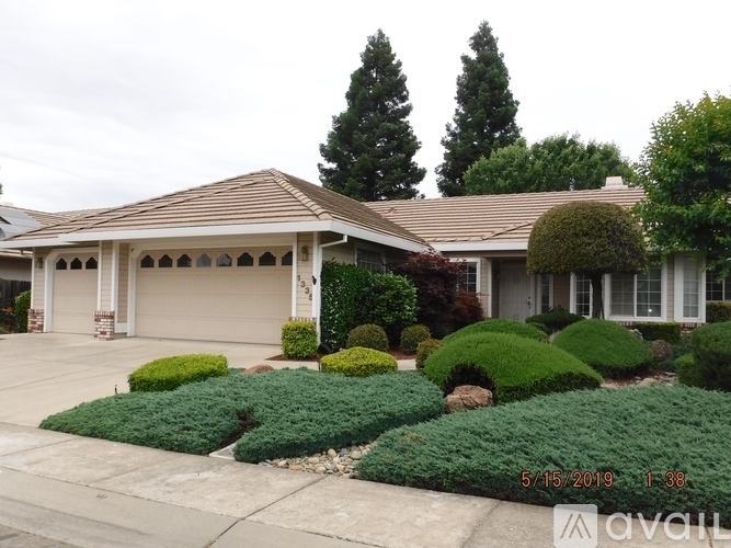 A house with a well-maintained lawn and landscaping is for sale.