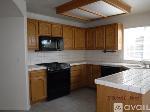 A kitchen with wooden cabinets and a black stove top oven.