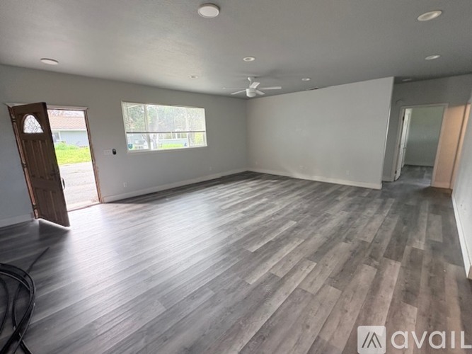 A room with wooden flooring and a ceiling fan.