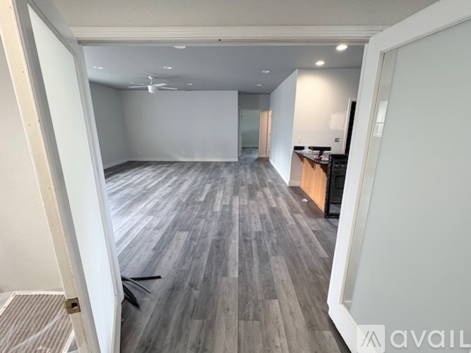 A spacious room with a grey floor and white walls.