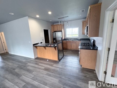 A kitchen with wooden cabinets and a black countertop.