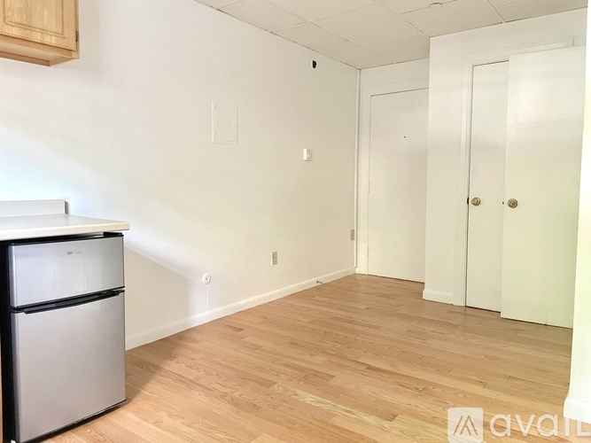 A kitchen with a white fridge and a white door.