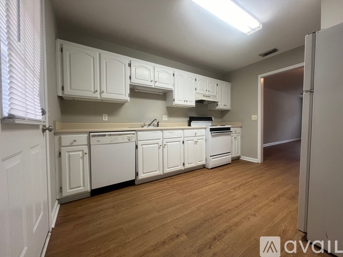 A kitchen with white cabinets and appliances.