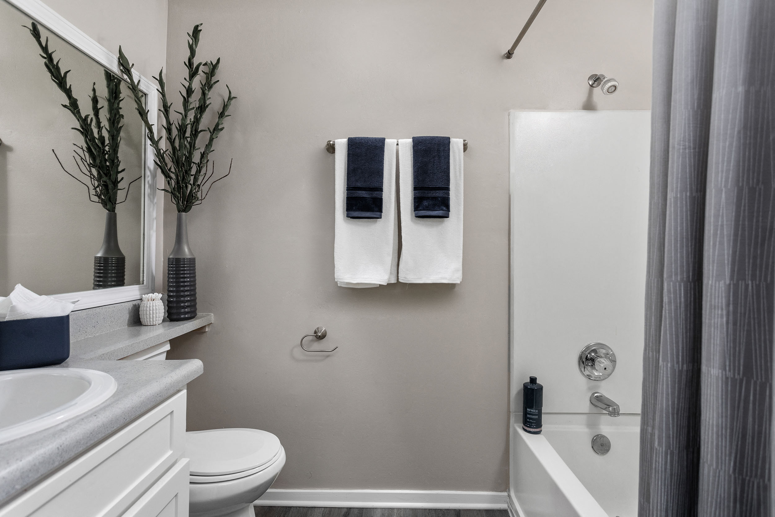 Full bathroom with white tub and shower and large vanity and mirror