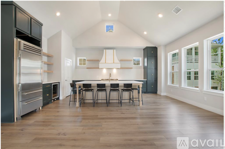 A modern kitchen with a large island and stainless steel appliances.