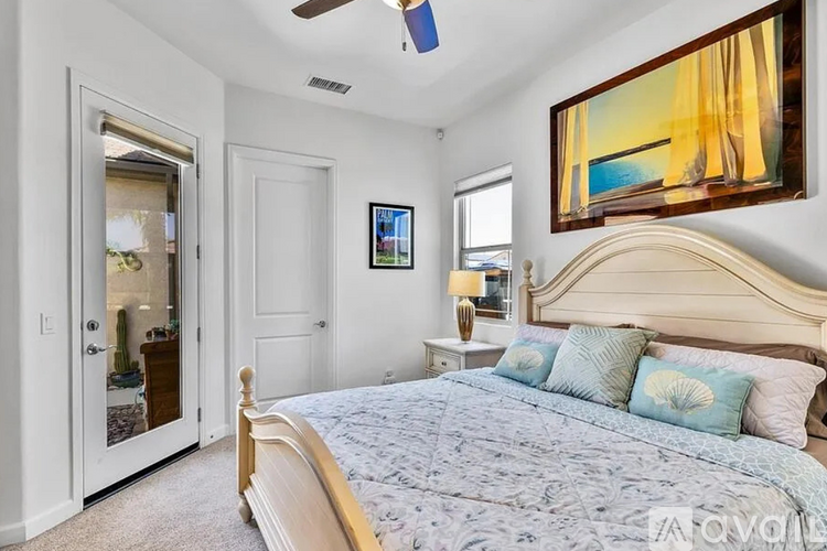 A bedroom with a large bed and a painting on the wall.