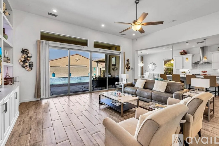 A living room with a grey couch and a ceiling fan.