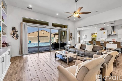 A living room with a grey couch and a ceiling fan.