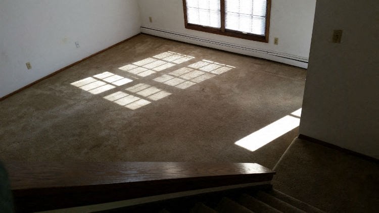 an empty room with sunlight coming through a window on the floor