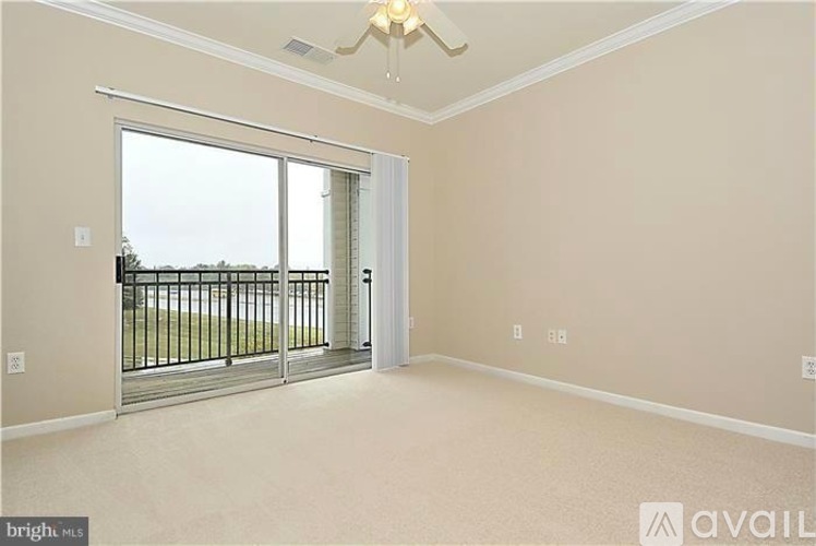 A room with a sliding glass door leading to a balcony.