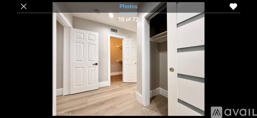 A hallway with a white door and a wooden floor.