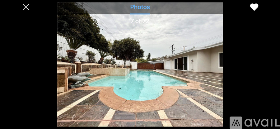 A swimming pool surrounded by a tiled patio.