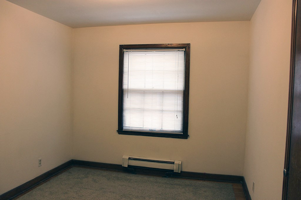 a small room with a window and a radiator