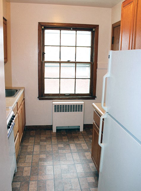 a small kitchen with a window and a white refrigerator