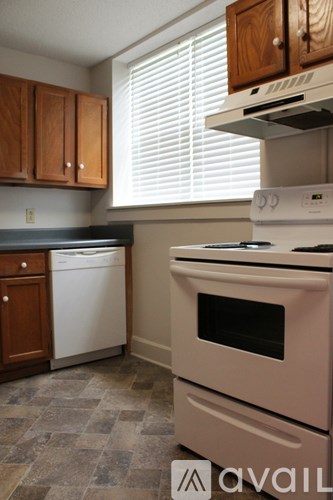 A kitchen with a white stove top oven and a dishwasher.