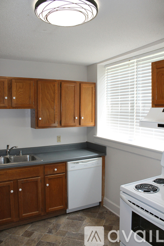 A kitchen with wooden cabinets and a white dishwasher.