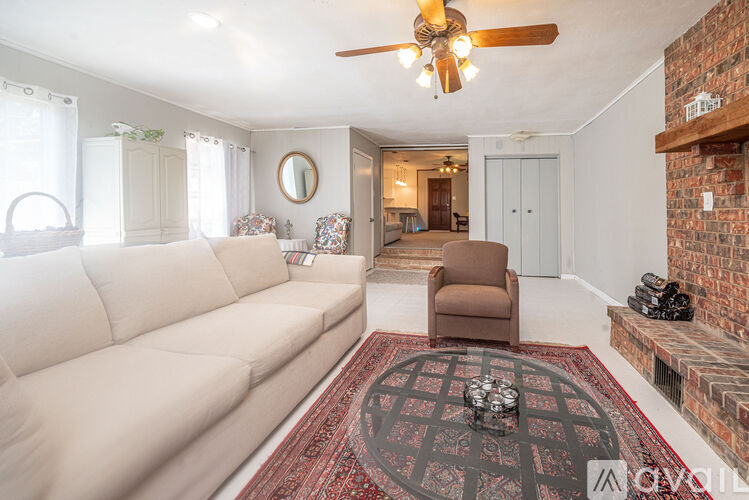 A living room with a white couch and a brown chair.