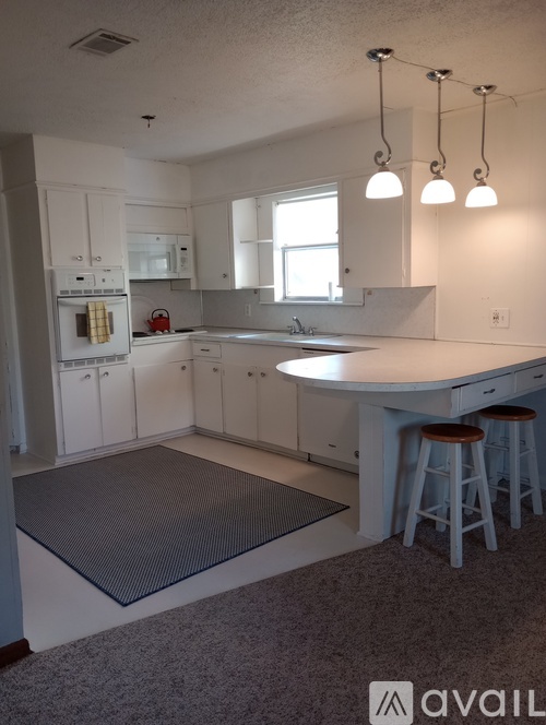 A kitchen with white cabinets and a large island.
