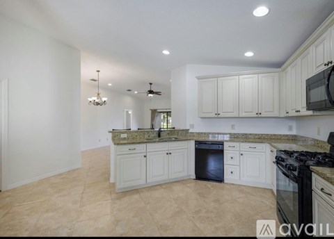 A kitchen with white cabinets and a black stove top oven.