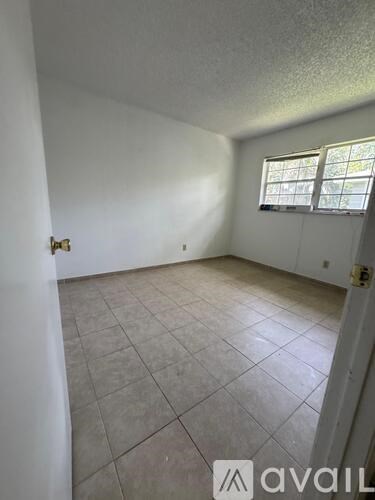 A room with a tile floor and a window with bars on it.
