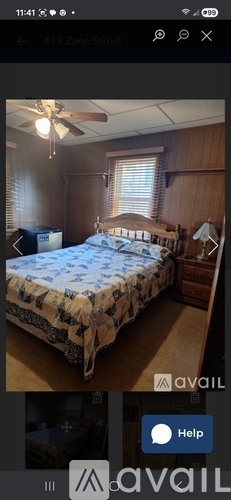 A bedroom with a bed, dresser, and ceiling fan.