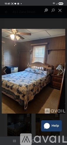 A bedroom with a bed, dresser, and ceiling fan.