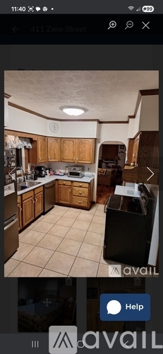 A kitchen with wooden cabinets and a black refrigerator.