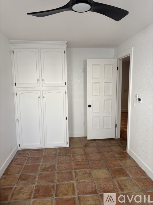 A room with a fan and a door.