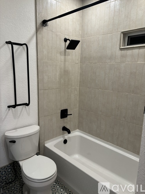 A white toilet sits next to a white bathtub in a bathroom.