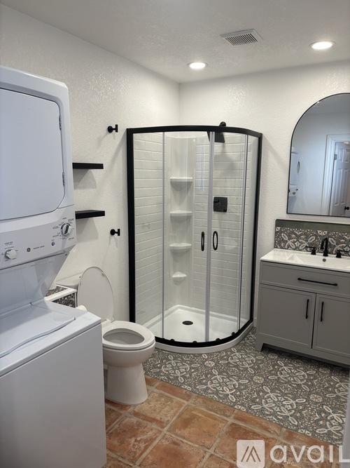 A bathroom with a toilet, sink, and shower.