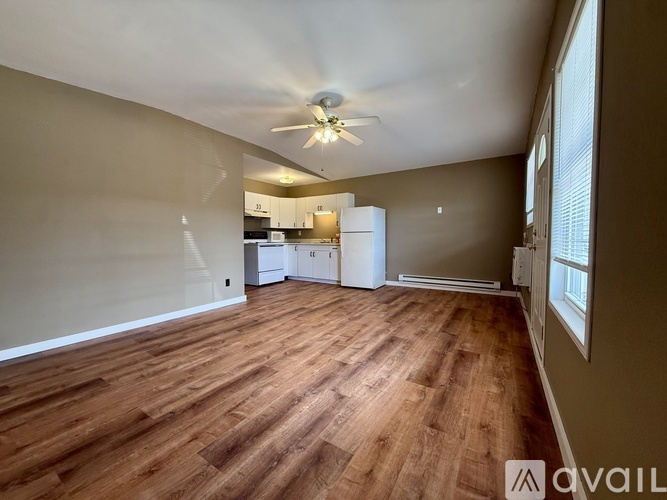 A room with wooden flooring and a ceiling fan.
