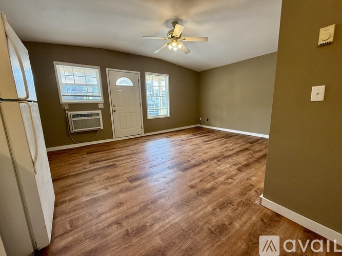 A room with a ceiling fan and wooden flooring.