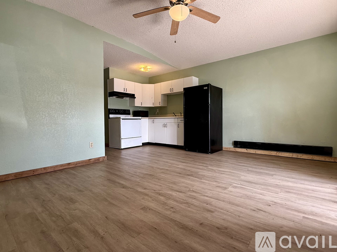 A room with a ceiling fan and wooden flooring.