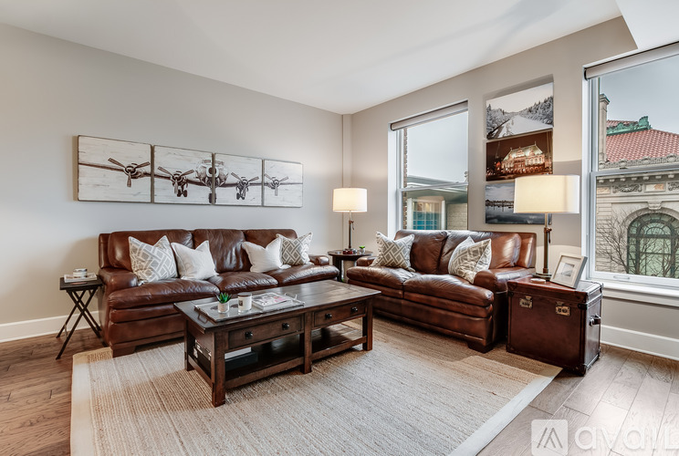 A living room with brown leather sofas and a wooden coffee table.