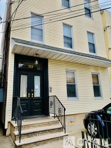 A house with a black front door and a black railing.