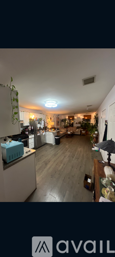A kitchen with wooden floors and a white ceiling.