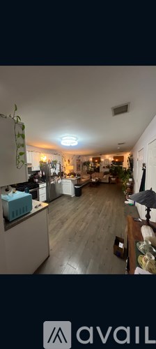 A kitchen with wooden floors and a white ceiling.