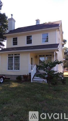 A two-story house with a front porch is for sale.