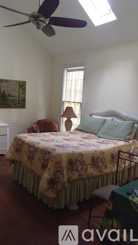 A bedroom with a bed and a ceiling fan.