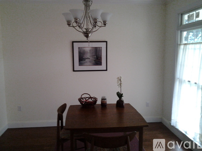 A dining room with a wooden table and chairs.