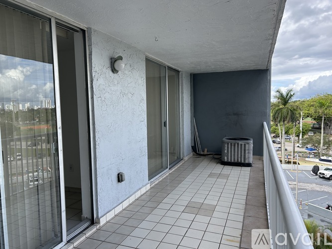 A balcony with tiled flooring and a metal railing.