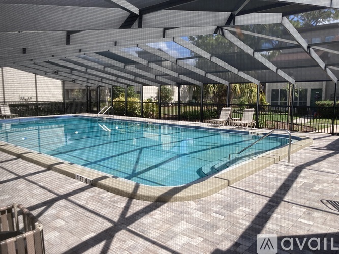 A pool under a canopy with a brick patterned floor.