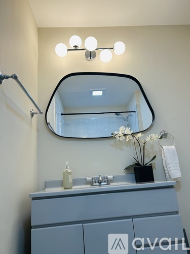 A bathroom vanity with a mirror and lights above it.