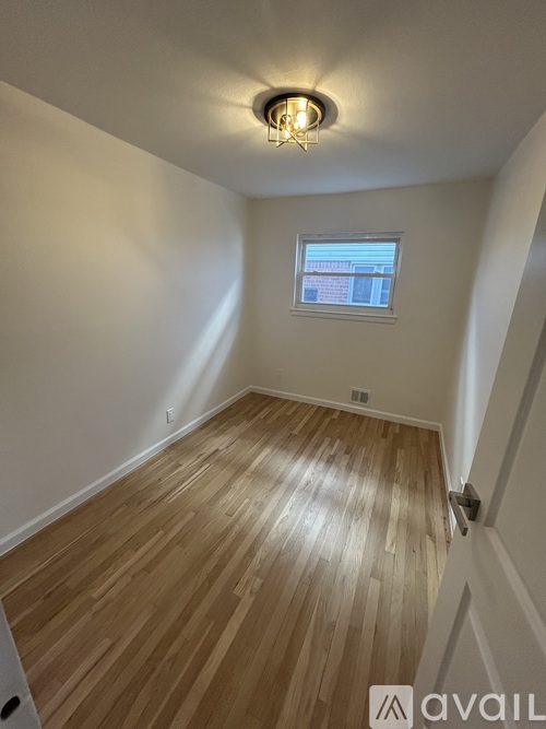A room with wooden flooring and a window.