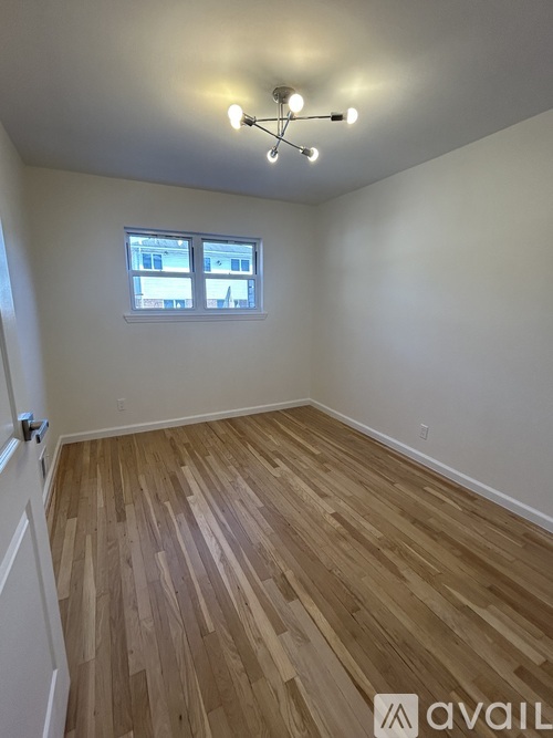 A room with wooden flooring and a window.