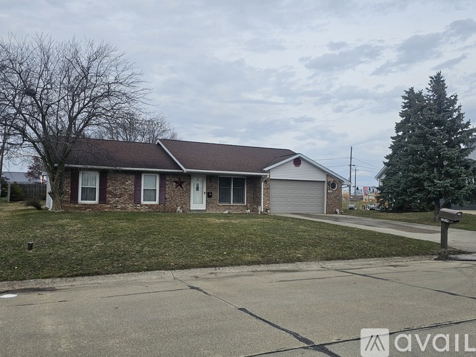 A house with a brown roof and a white garage door is for sale.